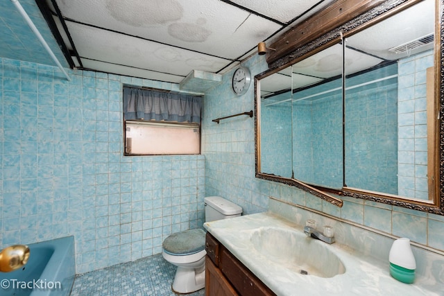 bathroom with vanity, toilet, and tile walls