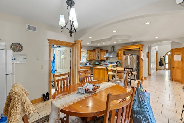 tiled dining room with a notable chandelier