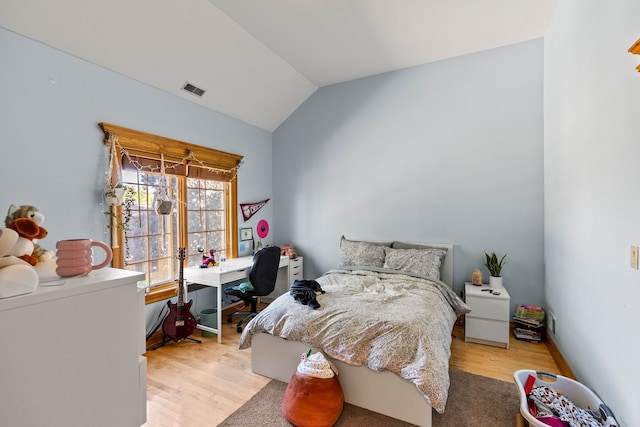 bedroom with lofted ceiling and light wood-type flooring