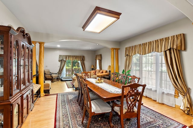 dining space with decorative columns and light hardwood / wood-style floors