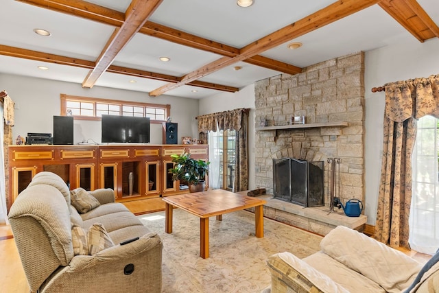 living room featuring beam ceiling, a stone fireplace, and coffered ceiling