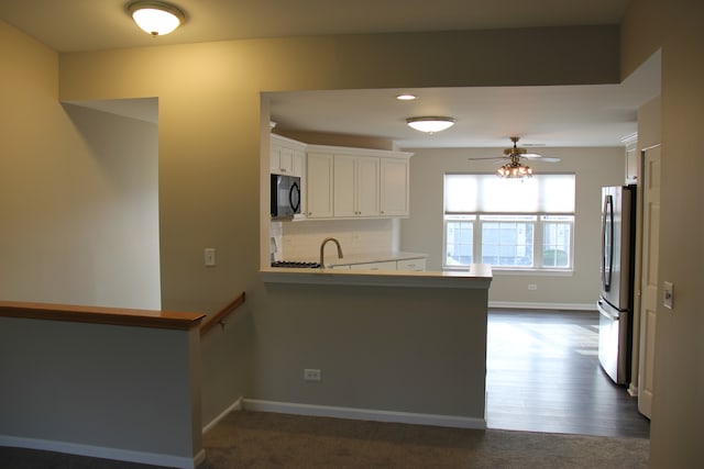 kitchen featuring kitchen peninsula, ceiling fan, dark wood-type flooring, white cabinetry, and stainless steel refrigerator