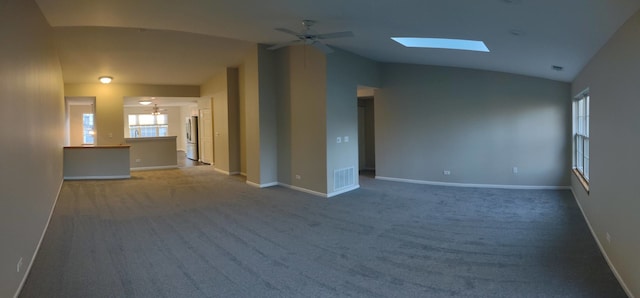 carpeted empty room with lofted ceiling with skylight and ceiling fan