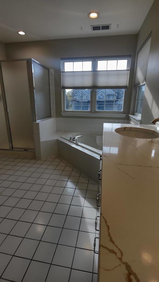 bathroom with a wealth of natural light, sink, shower with separate bathtub, and tile patterned flooring