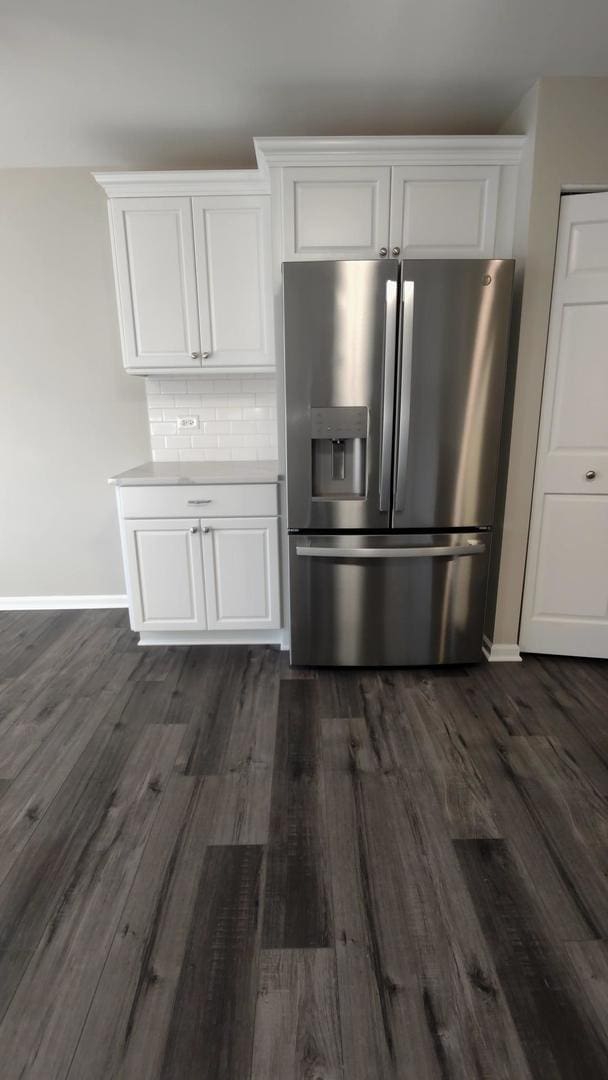 kitchen with backsplash, white cabinetry, dark hardwood / wood-style flooring, and stainless steel refrigerator with ice dispenser