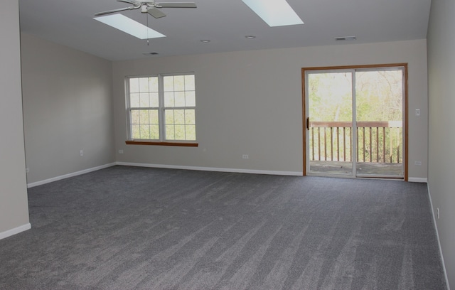 unfurnished room with dark colored carpet, a wealth of natural light, and ceiling fan