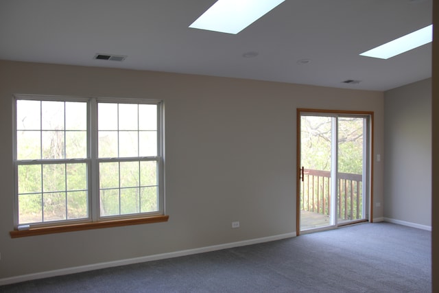 carpeted empty room featuring a skylight