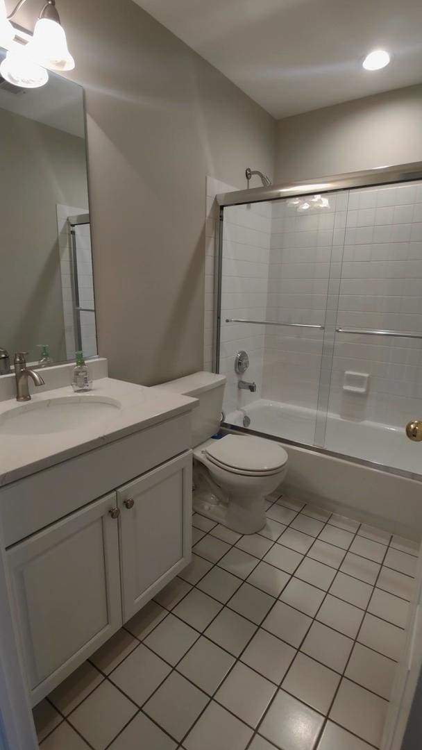 full bathroom with tile patterned flooring, vanity, toilet, and enclosed tub / shower combo