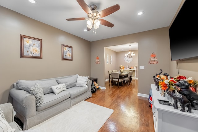 living room featuring hardwood / wood-style floors and ceiling fan with notable chandelier