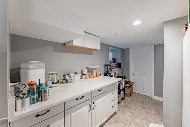 kitchen featuring white cabinets and light stone countertops