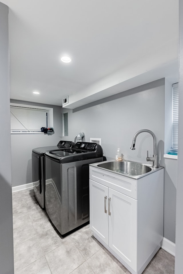 washroom featuring separate washer and dryer, sink, and cabinets