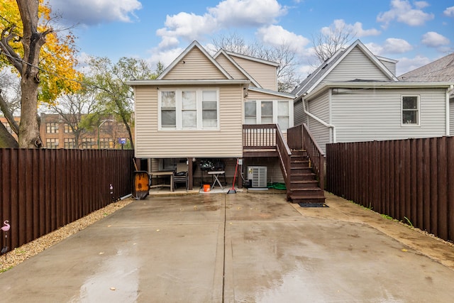 back of house with central AC unit and a wooden deck