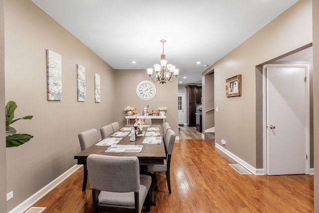 dining room with an inviting chandelier and light wood-type flooring