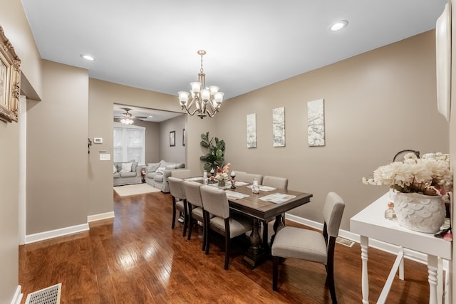 dining space featuring dark hardwood / wood-style floors and ceiling fan with notable chandelier