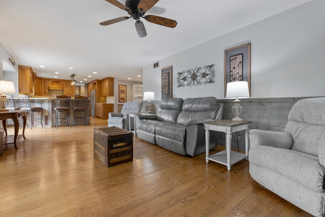 living room featuring ceiling fan and light wood-type flooring