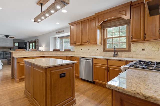 kitchen featuring a kitchen island, sink, light hardwood / wood-style floors, and stainless steel appliances