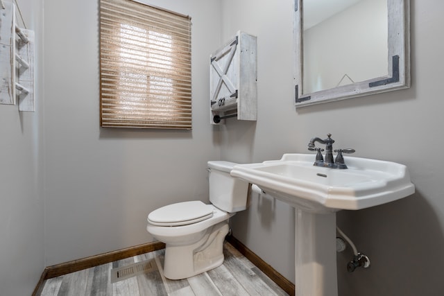 bathroom with hardwood / wood-style flooring and toilet