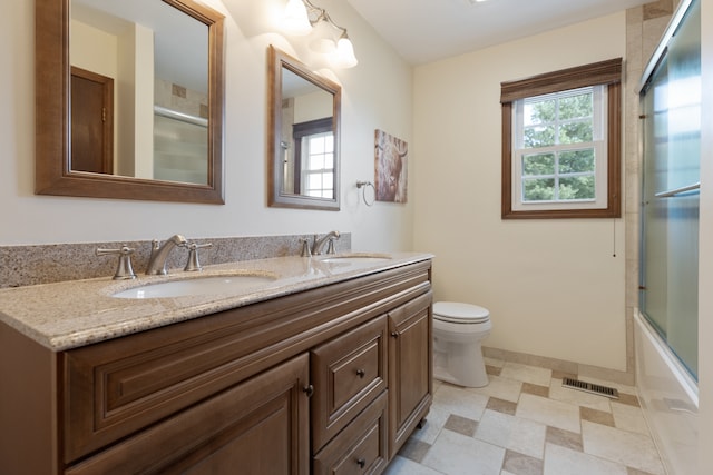 full bathroom with vanity, combined bath / shower with glass door, and toilet