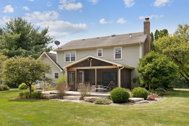 back of house featuring a sunroom and a yard