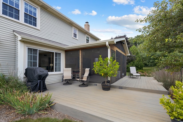 wooden deck with grilling area and a sunroom