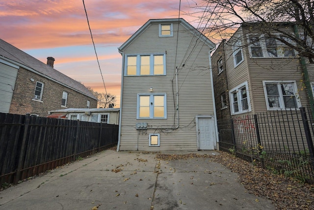 back house at dusk with a patio