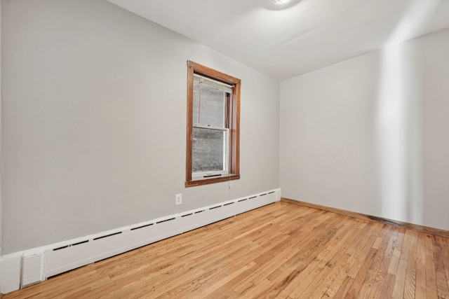 empty room featuring light hardwood / wood-style flooring and a baseboard heating unit