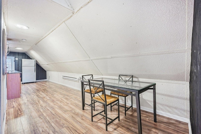 dining space with hardwood / wood-style floors and vaulted ceiling