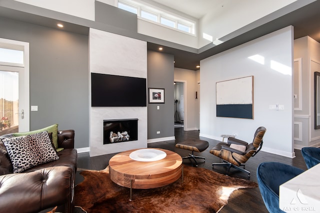 living room with a towering ceiling and hardwood / wood-style flooring