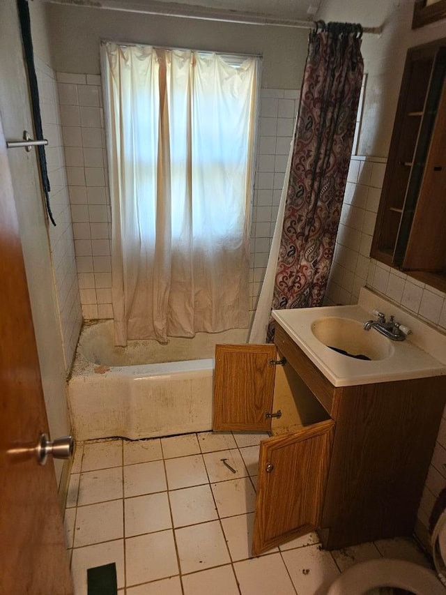 full bathroom featuring tasteful backsplash, tile patterned floors, toilet, shower / bath combo with shower curtain, and vanity