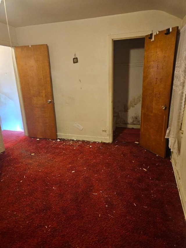 unfurnished bedroom with dark carpet