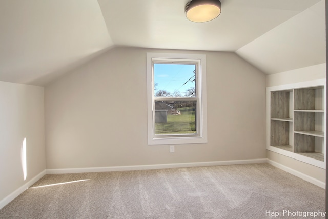 bonus room featuring light colored carpet and vaulted ceiling