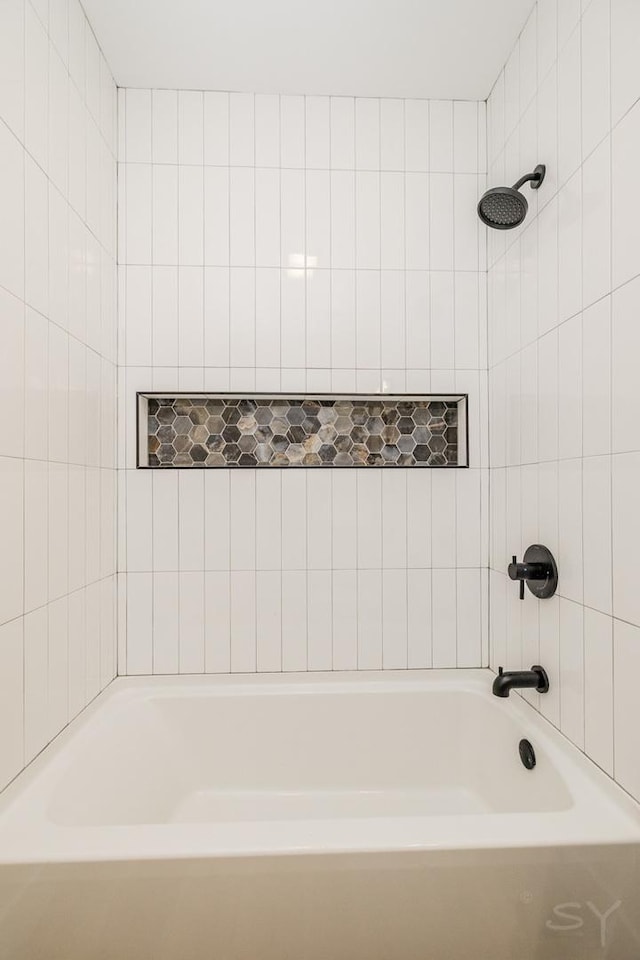 bathroom featuring tiled shower / bath