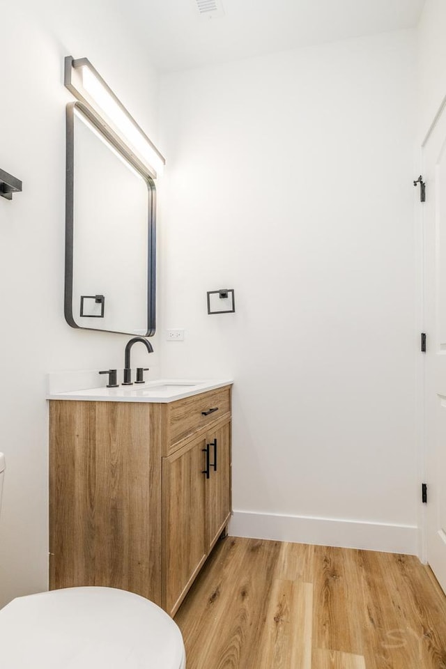 bathroom featuring hardwood / wood-style floors, vanity, and toilet