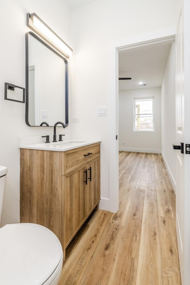 bathroom featuring vanity, hardwood / wood-style flooring, and toilet