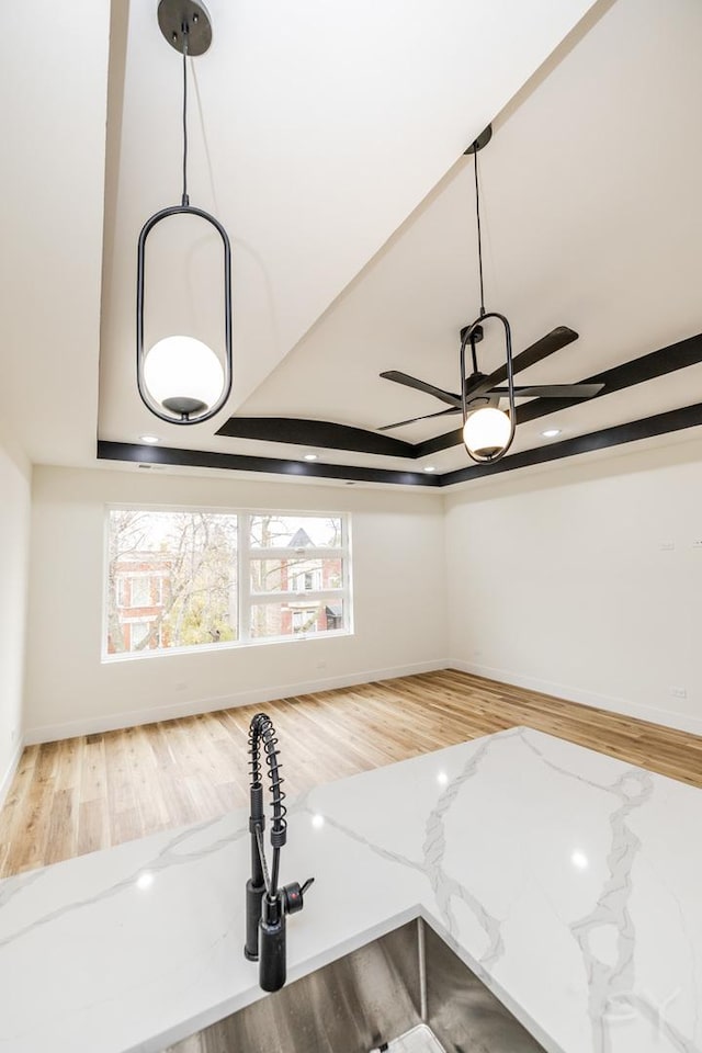 details with light stone countertops, ceiling fan, and hanging light fixtures