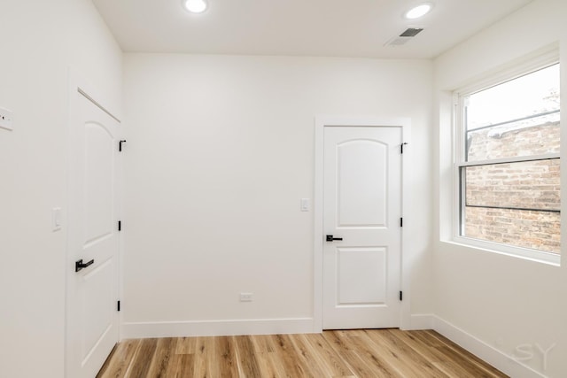 empty room with light wood-type flooring and plenty of natural light