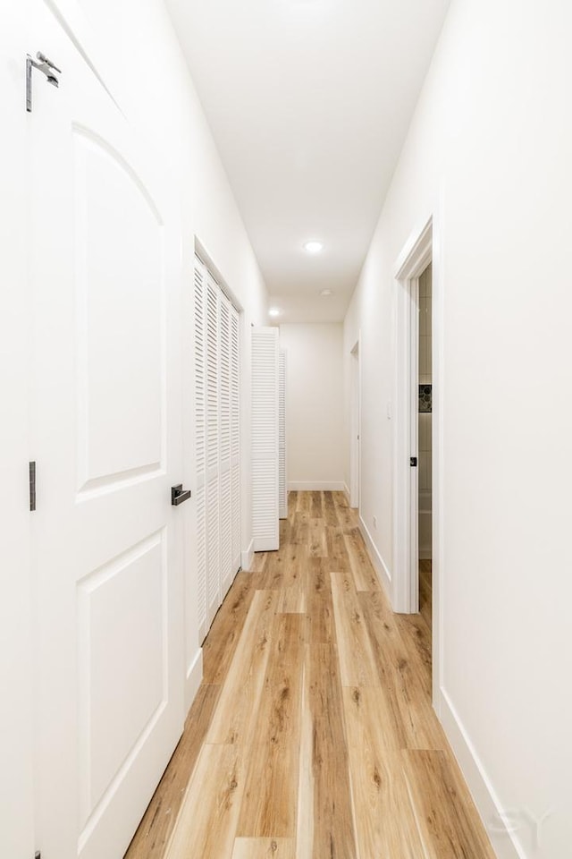 hallway with light hardwood / wood-style floors