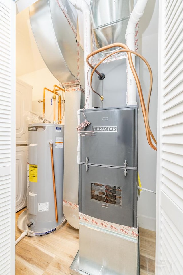 utility room featuring electric water heater and heating unit