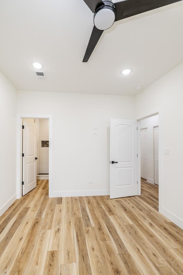 empty room with ceiling fan and light hardwood / wood-style floors