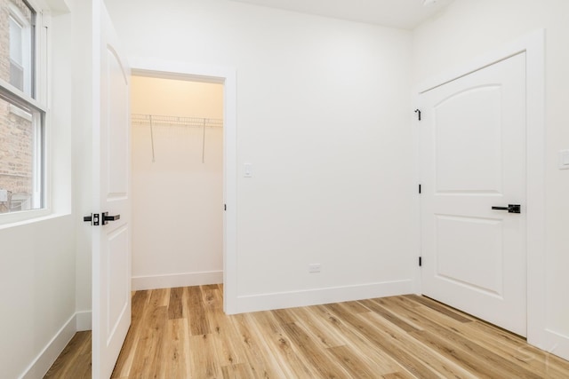 unfurnished bedroom with a closet and light hardwood / wood-style flooring