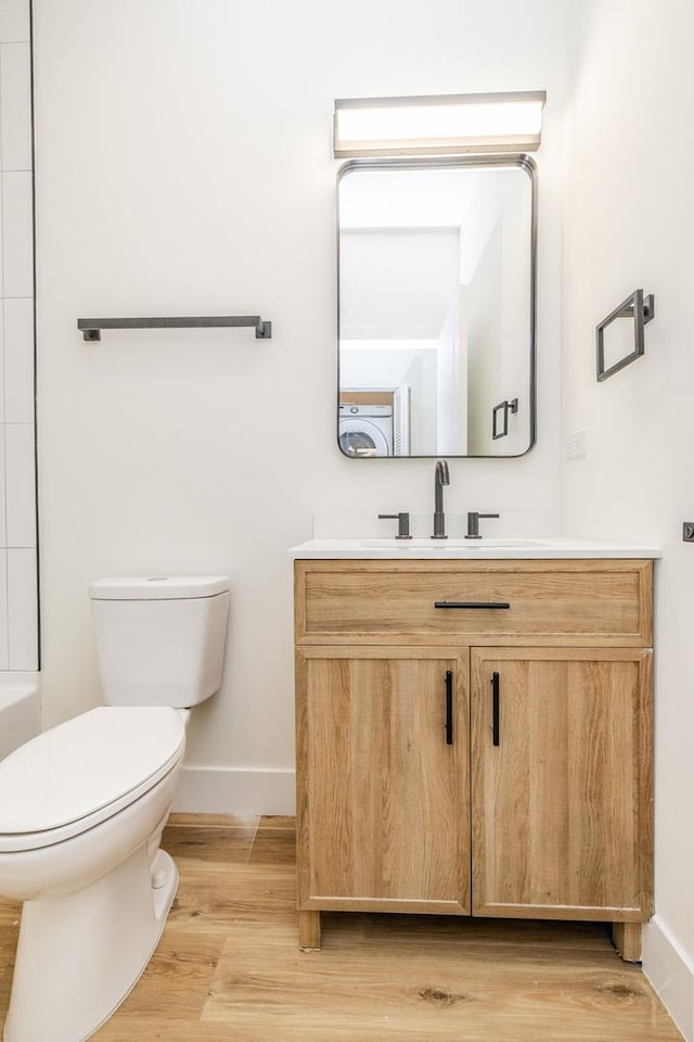 bathroom with hardwood / wood-style flooring, vanity, and toilet