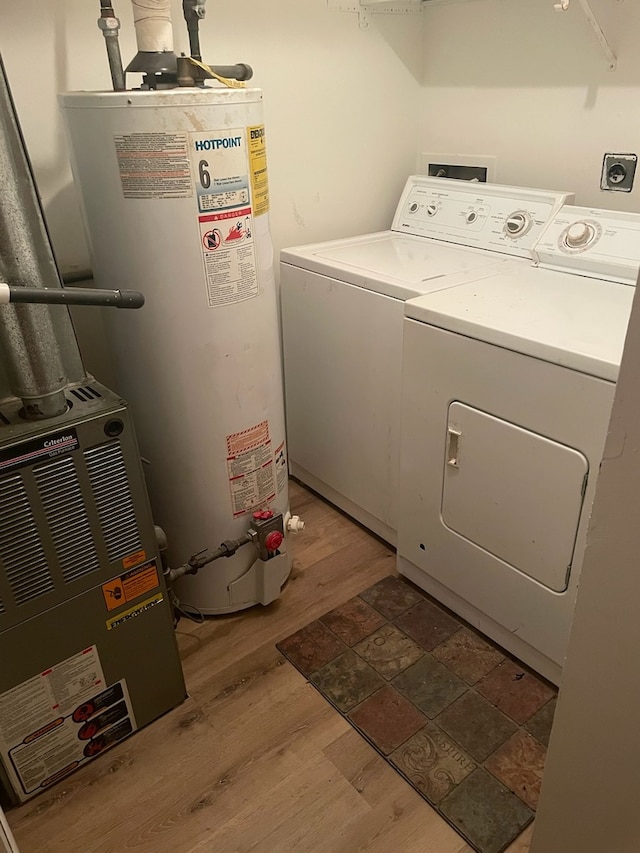 washroom featuring independent washer and dryer, gas water heater, and wood-type flooring