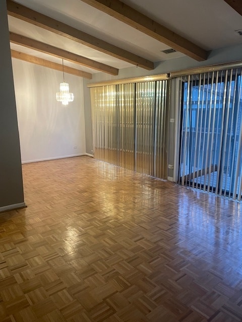 unfurnished room with parquet flooring, beamed ceiling, and an inviting chandelier