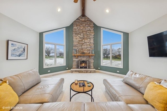 living room featuring vaulted ceiling with beams, light colored carpet, a stone fireplace, and ceiling fan