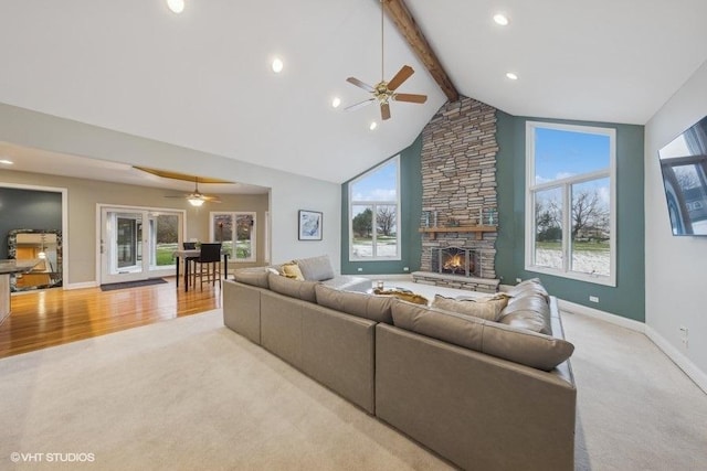 living room with beam ceiling, plenty of natural light, and light wood-type flooring