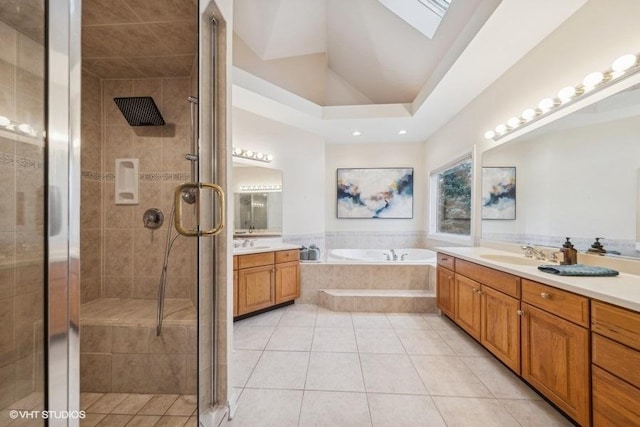 bathroom with a skylight, tile patterned flooring, vanity, and shower with separate bathtub