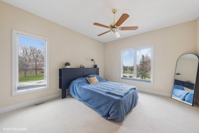 bedroom featuring ceiling fan, carpet floors, and multiple windows