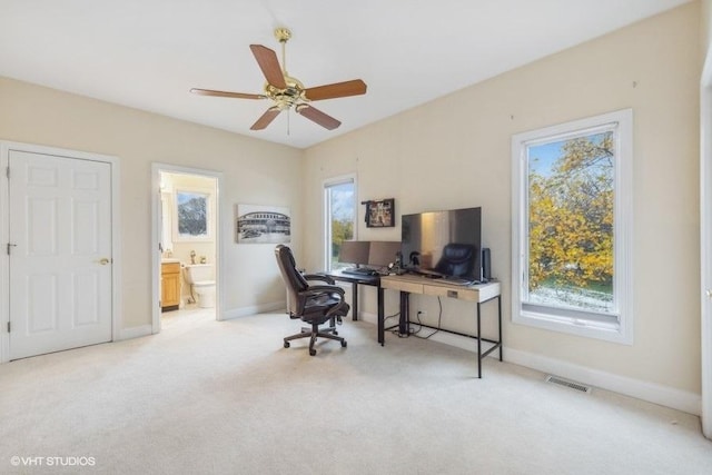 carpeted home office featuring ceiling fan and a healthy amount of sunlight