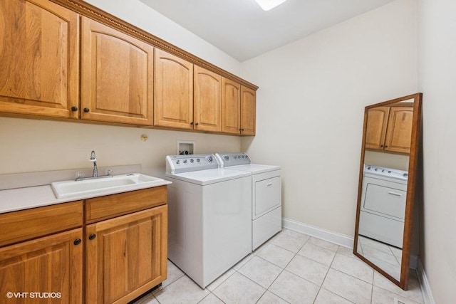 washroom featuring cabinets, independent washer and dryer, light tile patterned flooring, and sink