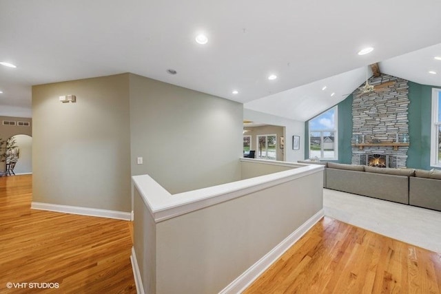 hallway featuring vaulted ceiling and light hardwood / wood-style flooring